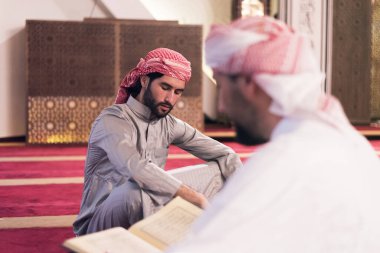 İki katır etnik dindar genç insan birlikte Kur 'an okuyup namaz kılıyorlar. Camide namaz kılan bir grup müslüman..