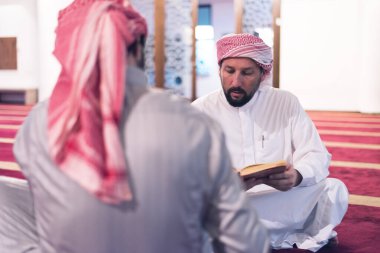 İki katır etnik dindar genç insan birlikte Kur 'an okuyup namaz kılıyorlar. Camide namaz kılan bir grup müslüman..