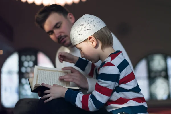 종교적 이슬람 아들에게 코란으로 하나님 기도하고 이슬람 사원에서 — 스톡 사진