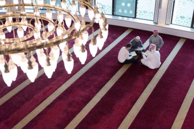 Bir grup dindar Müslüman genç insan güzel modern camide Kur 'an okuyup namaz kılıyorlar..