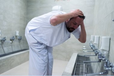 Müslüman adam dua için abdest alıyor. İslami Dini Af Töreni. Ey müslüman delikanlı, namaz kılmadan önce namaz kıl / dua et..