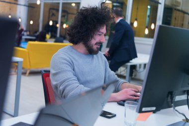 Yaratıcılık alanında çalışan genç bir adam. Modern çalışma alanının içinde yeni yaratıcı dijital projeler üzerinde çalışıyoruz..