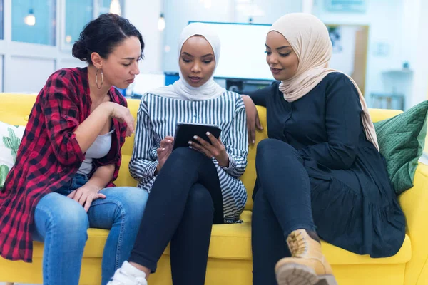 多族裔的年轻女企业家作为一个团队开展工作的多样化群体 两名穆斯林头巾和一名美国女性同事讨论现代共同工作空间内的重要问题 — 图库照片