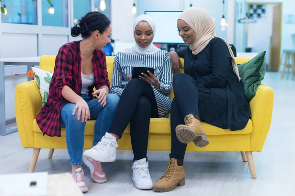 多族裔的年轻女企业家作为一个团队开展工作的多样化群体 两名穆斯林头巾和一名美国女性同事讨论现代共同工作空间内的重要问题 — 图库照片