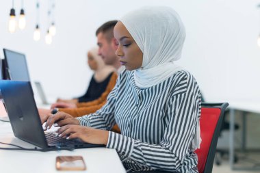 Genç Müslüman Afrikalı Amerikalı iş kadını lider olarak iş başında. Takım çalışması ve çok ırklı kavram. Ofisinde çalışan başarılı bir iş adamı..