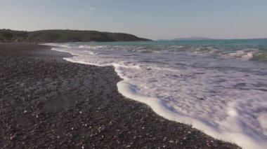 Yunanistan 'da dalgalar yavaş çekimde boş plaja çarpıyor