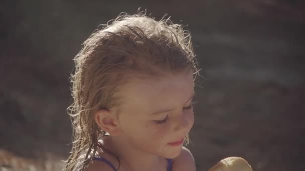 Bella Bambina Mangiare Una Grande Ciambella Sulla Spiaggia — Video Stock