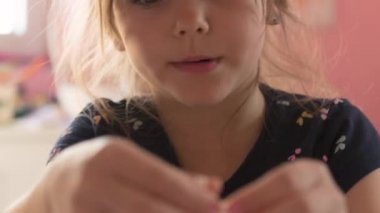 Güzel küçük kız odasında masasında oturmuş portakal suyu çiziyor ve içiyor.