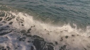 Boş bir sahile vuran dalgalara yakın çekim, yavaş çekim.
