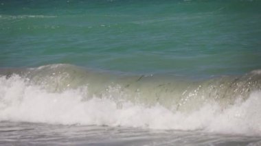 Boş bir sahile vuran dalgalara yakın çekim, yavaş çekim.
