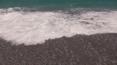 Boş bir sahile vuran dalgalara yakın çekim, yavaş çekim.