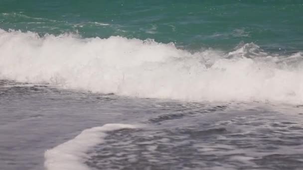 Gros plan des vagues qui s'écrasent sur une plage vide, au ralenti 