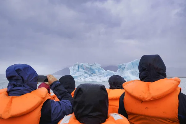 Un grupo de personas está haciendo un viaje en barco a la Laguna Glaciar Jokulsarlon en Islandia. El barco rodeado de icebergs — Foto de Stock