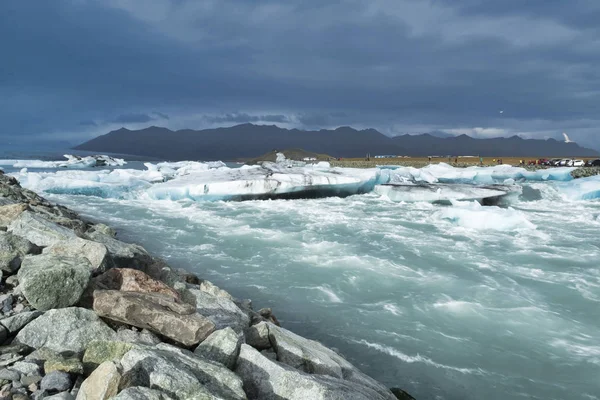 Icebergs flutuando na água fria da lagoa glacial Jokulsarlon. Parque Nacional Vatnajokull, no sudeste da Islândia, durante uma viagem de carro — Fotografia de Stock