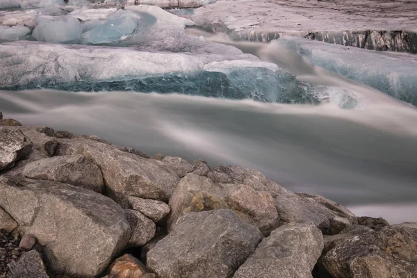İzlanda 'da Jokulsarlon Buzul Gölü. Uzun pozlu çekim suyu ve gökyüzünü ipeksi yapar. Uzun pozlama, buzul, karamsar kavramlar