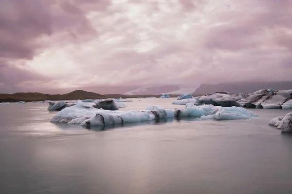 İzlanda 'da Jokulsarlon Buzul Gölü. Uzun pozlu çekim suyu ve gökyüzünü ipeksi yapar. Uzun pozlama, buzul, karamsar kavramlar — Stok fotoğraf