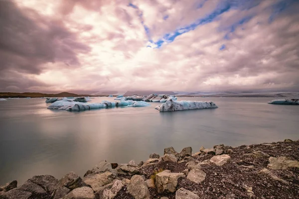 Ледниковая лагуна Джоколсарлон в Исландии. Длительный выстрел делает воду и небо шелковистыми. Длительное воздействие, ледник, угрюмые концепции — стоковое фото