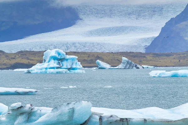 Айсберги плавают в холодной воде ледниковой лагуны Джоколсарлон. Национальный парк Ватнайокулл на юго-востоке Исландии во время дорожной поездки — стоковое фото