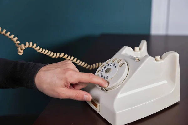 Phone old retro, old fashioned white telephone against green background, woman hand holding telephone cord — Stock Photo, Image