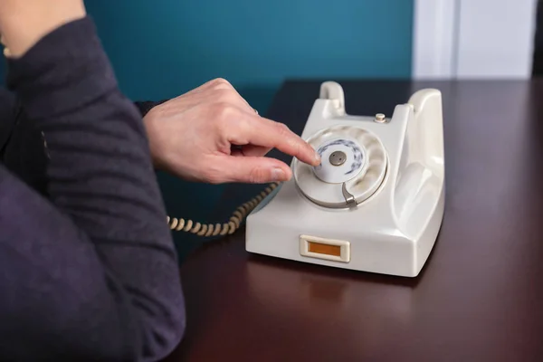 Phone old retro, old fashioned white telephone against green background, woman hand holding telephone cord in long exposure — Stock Photo, Image