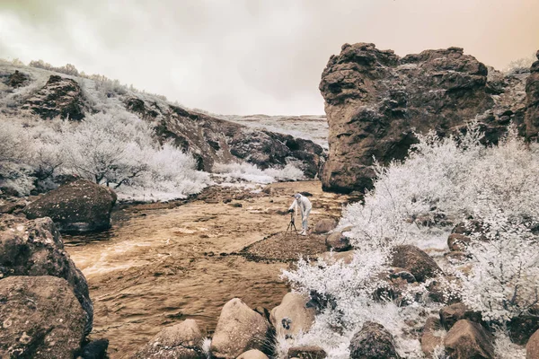 Een infrarood blik op het landschap van IJsland, een vrouw maakt foto 's — Stockfoto