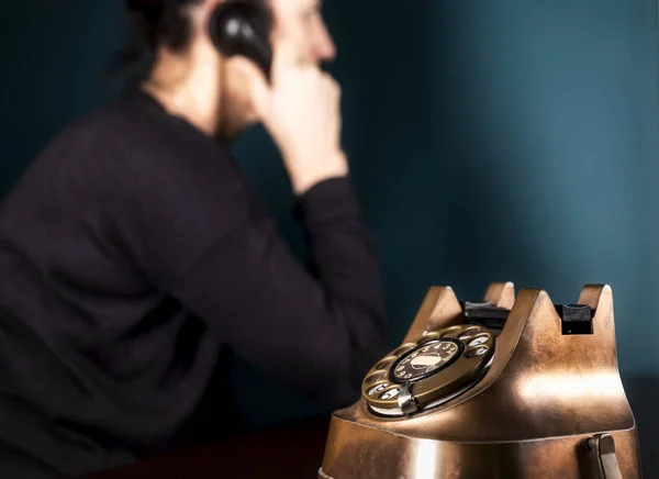 Portrait of young Hispanic woman talking on vintage telephone, green wall old brown table — Stock Photo, Image