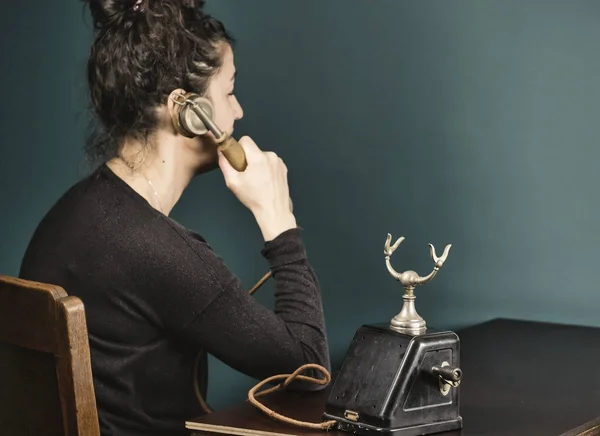 Portrait of young Hispanic woman talking on vintage telephone, green wall old brown table — Stock Photo, Image