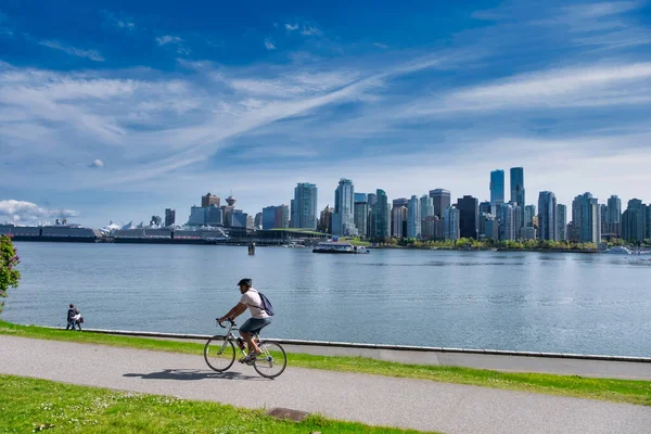 Vancouver - květen 05 2019: Centrum Vancouveru, Kanada.Pohled na centrum Vancouveru, ze Stanley parku, muž na kole v popředí — Stock fotografie