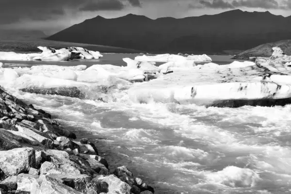 Παγόβουνα επιπλέουν στο κρύο νερό της παγωμένης λιμνοθάλασσας Jokulsarlon. Εθνικό Πάρκο Vatnajokull, στη νοτιοανατολική Ισλανδία κατά τη διάρκεια ενός οδικού ταξιδιού, vintage ασπρόμαυρο — Φωτογραφία Αρχείου