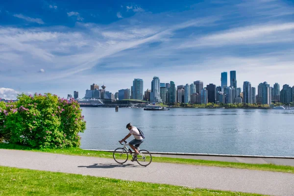 Vancouver - květen 05 2019: Centrum Vancouveru, Kanada.Pohled na centrum Vancouveru, ze Stanley parku, muž na kole v popředí — Stock fotografie