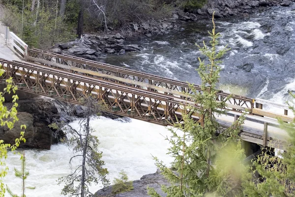 Vista aérea de un puente sobre un río en las Rocosas Canadienses durante un vibrante día soleado de verano. Situado en Columbia Británica, Canadá — Foto de Stock