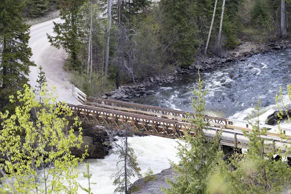 Vista aérea de un puente sobre un río en las Rocosas Canadienses durante un vibrante día soleado de verano. Situado en Columbia Británica, Canadá — Foto de Stock