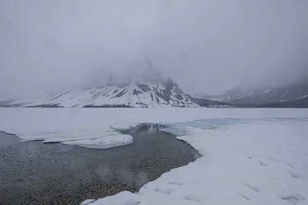 Μια γαλήνια σκηνή μιας ήρεμης λίμνης που περιβάλλεται από βουνά που καλύπτονται από χιόνι, Jasper, Καναδάς — Φωτογραφία Αρχείου