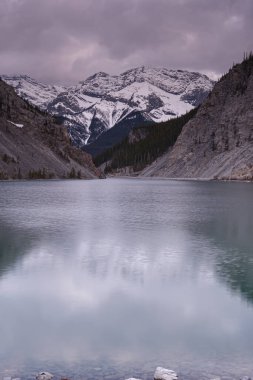 Sonbahar ormanı ve Kanada kayalıklarında yansımaları olan renkli bir göl. Grassi gölleri Canmore yakınlarındaki Rocky Dağları 'nda. Alberta. Kanada