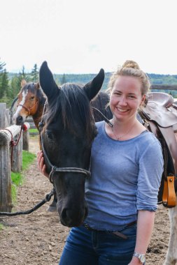 Banff Ulusal Parkı 'nda eyerli bir atı olan genç bir kadın.