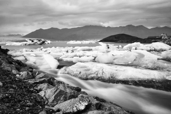 Ледниковая лагуна Джоколсарлон в Исландии. Длительный выстрел делает воду и небо шелковистыми. Длительное воздействие, ледник, угрюмые концепции, черно-белый винтаж — стоковое фото