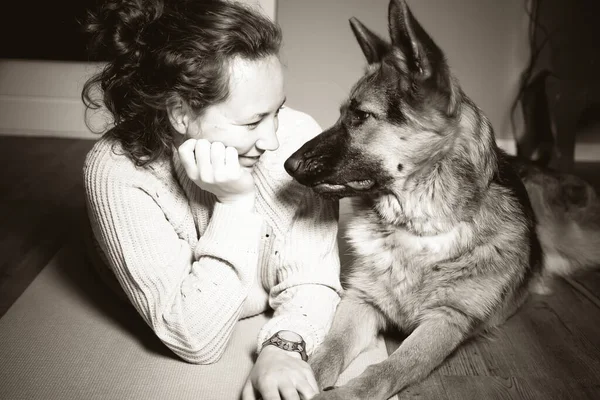 Alman çoban köpeğiyle rahatlatıcı bir kadının klasik siyah beyaz fotoğrafı. — Stok fotoğraf