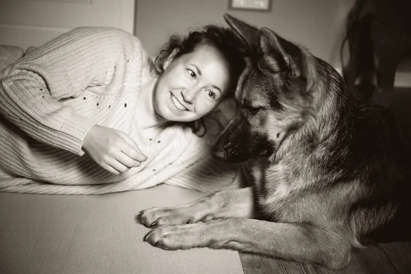 Alman çoban köpeğiyle rahatlatıcı bir kadının klasik siyah beyaz fotoğrafı. — Stok fotoğraf