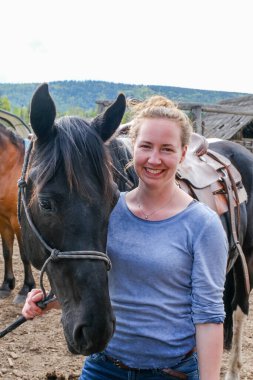 Banff Ulusal Parkı 'nda eyerli bir atı olan genç bir kadın.