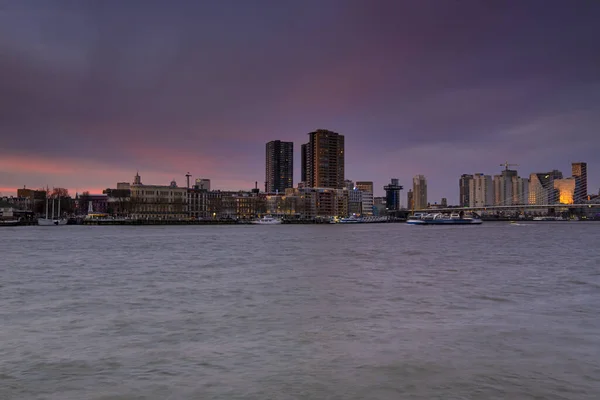 Rotterdam - 12 de fevereiro de 2019: Rotterdam, Holanda O horizonte de Rotterdam à noite, crepúsculo. Canal Maas em primeiro plano. Roterdão, Países Baixos — Fotografia de Stock