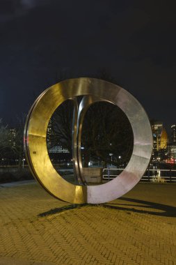 The Hague, the Netherlands - 18 February 2019: Koninginnegracht. Artwork: Pressed circles by Andre van Lier. Golden circles with a view of the high buildings, Castalia, Helicon, de Zurichtoren en de