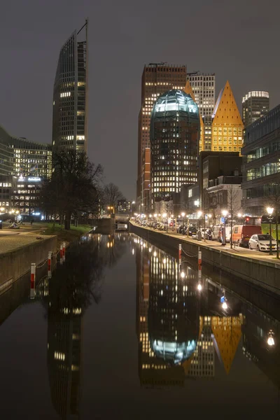 The Hague, the Netherlands - 18 February 2019: Skyline of The Hague at night with canal in front and high buildings , Castalia, Helicon, Zurichtoren and the Muzentoren in background — Stock Photo, Image