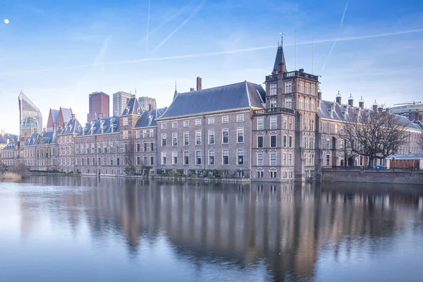 The Hague - February 17 2019: The Hague, The Neherlands. Binnenhof castle, Dutch Parliament, with the Hofvijver lake, against a background of skyscrapers and blue sky, twilight, blue hour, The Hague — Stock Fotó