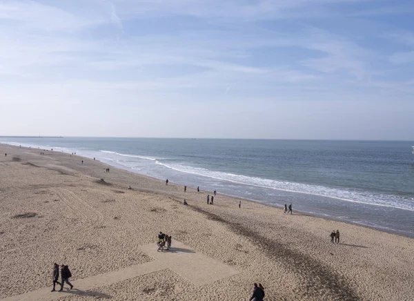 Scheveningen, 18 februari 2019: Scheveningen, Den Haag, Nederland. Landschap aan zee, uitzicht op het strand, mensen die over het strand lopen. Nederland — Stockfoto