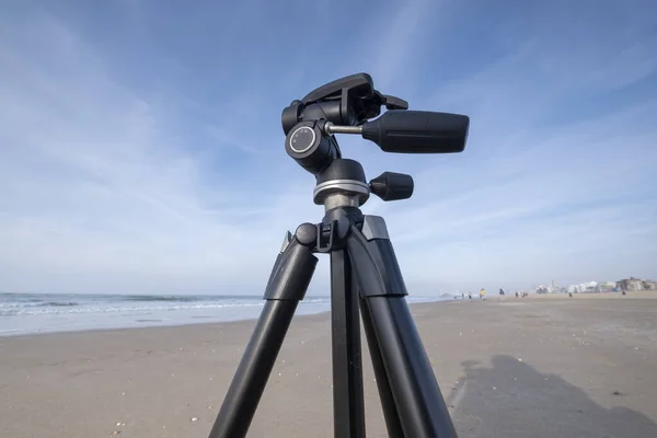 A part of a tripod on a yellow sand beach, on the background blue Sea and sky, Scheveningen, The Hetherlands