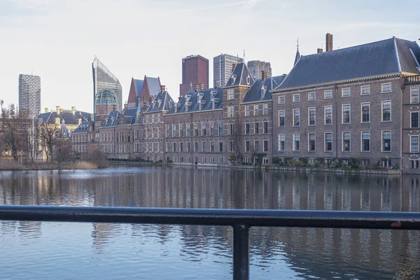 The Hague - February 17 2019: The Hague, The Neherlands. Binnenhof castle, Dutch parliament. during golden hour, with the Hofvijver lake, cast iron fence in foreground , The Hague, Den Haag, The — Stock Photo, Image