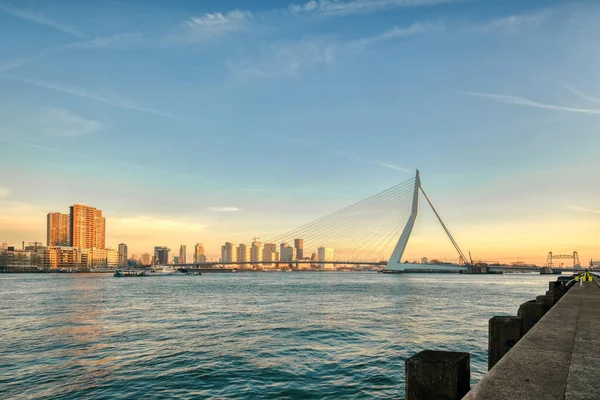 Rotterdam - 2019. február 14.: Rotterdam, Hollandia belvárosa alkonyatkor Dél-Hollandiában, Rotterdamban. Erasmus híd a jobb oldalon — Stock Fotó