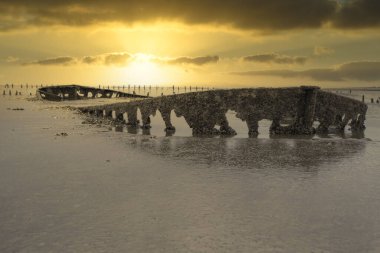 Görkemli bulutlu Wierum enkazının özel bir resmi. Bahar mevsiminde boşalmış deniz.