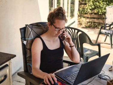 Kilitleme sırasında evde dizüstü bilgisayar, akıllı telefon ve defterle çalışmak, Covid-19 konsepti