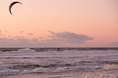 Extreme Sport Kitesurfing, ufukta kargo gemileri. Gün batımında Scheveningen 'de denizde sörfçü..